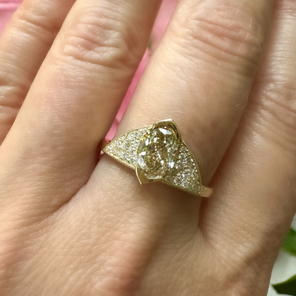 A stunning 18k yellow gold and diamond ring with the most beautiful light brown SI2 1.00ct champagne oval diamond and approximately 0.19cttw F/VS round brilliant cut diamonds hand pavé set for maximum sparkle. This Art Deco inspired design with a modern twist can be worn as an engagment ring with room below the center diamond for stacking a complementary straight wedding band. Or, it is a fabulous everyday addition to your ring game. This one was designed custom for a client and I'd love to make you your ow